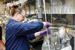 A woman dress chemical protective workwear on the job