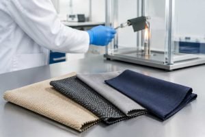 Fabric samples are displayed beside a technician testing a sample in a laboratory.