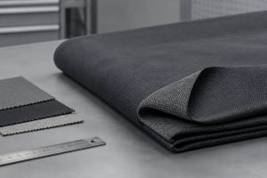 A length of dark protective fabric arranged on a worktable.